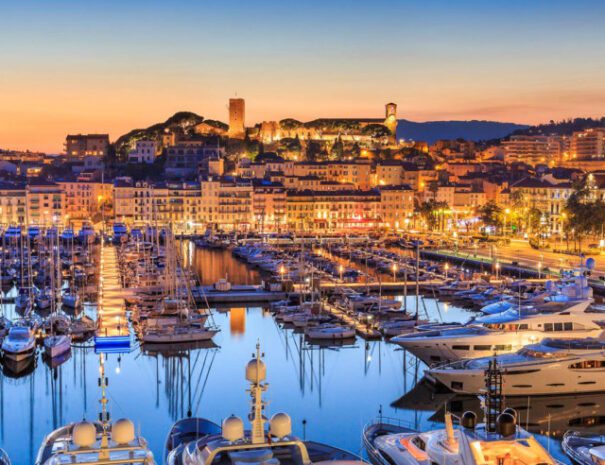 Admirez un panorama spectaculaire du Vieux Port de Cannes, où les yachts et les bateaux de pêche se mêlent harmonieusement, avec le quartier historique du Suquet en arrière-plan, illuminé par les couleurs chaudes du coucher de soleil. Ce moment magique offre une vue imprenable sur la baie de Cannes, le tout dans une atmosphère paisible et pittoresque.