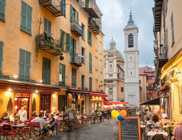 Découvrez une ruelle typique du Vieux-Nice, où les façades colorées, les volets en bois et les étals de marché créent une atmosphère authentique et chaleureuse. Ces ruelles étroites, bordées de boutiques artisanales et de cafés traditionnels, invitent à la flânerie et à l'exploration du riche patrimoine niçois. Le Vieux-Nice, cœur historique de la ville, est un véritable dédale de ruelles pittoresques, chacune offrant une expérience unique et un aperçu de la vie locale.